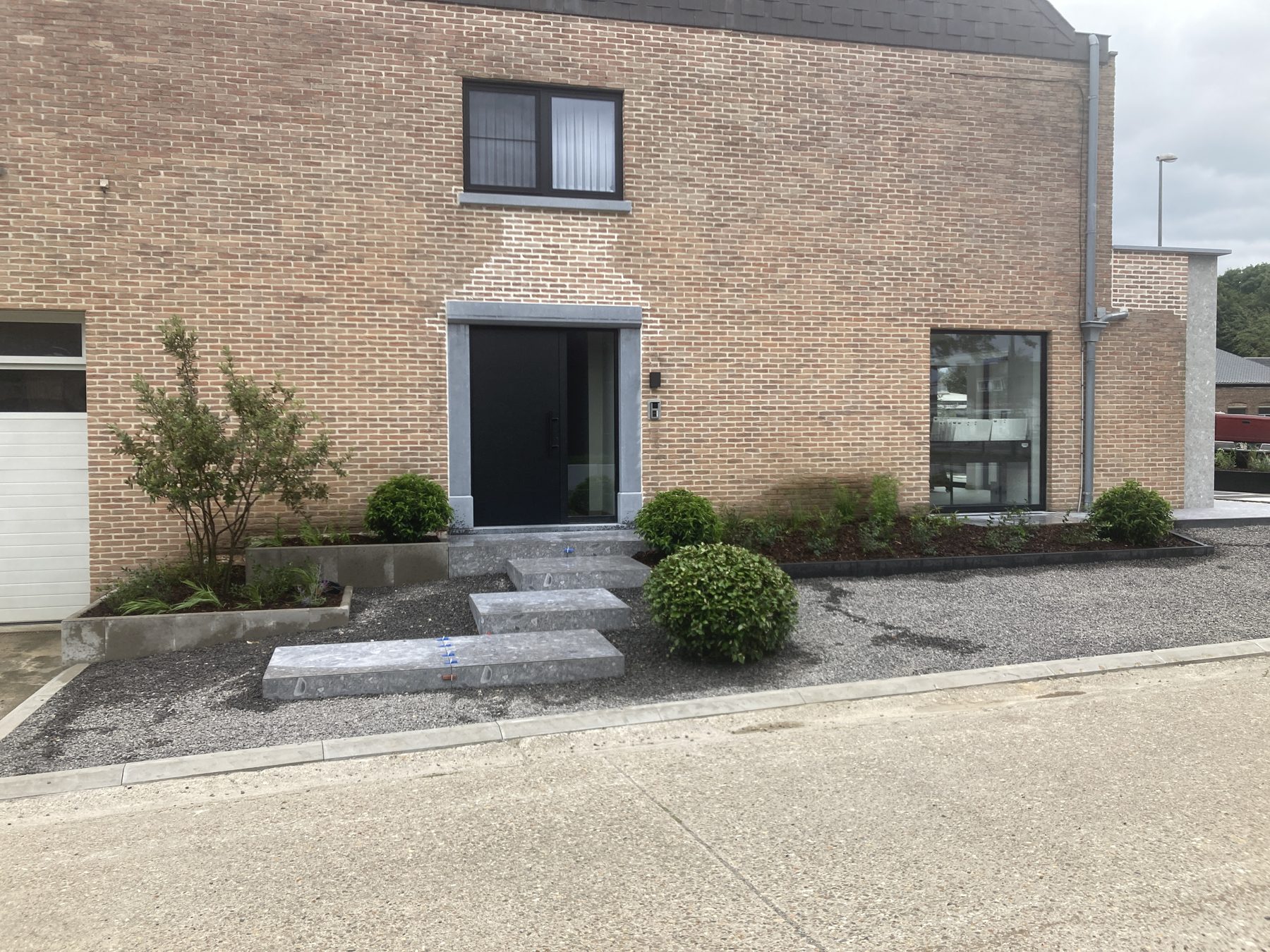 Voortuin met beplanting en grindverharding